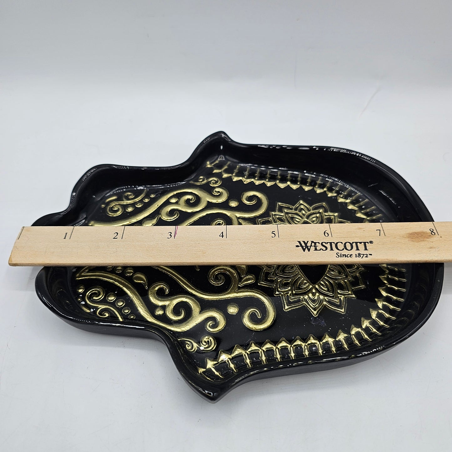 Hamsa hand trinket dish with black glaze, intricate gold-toned evil eye and mandala detailing