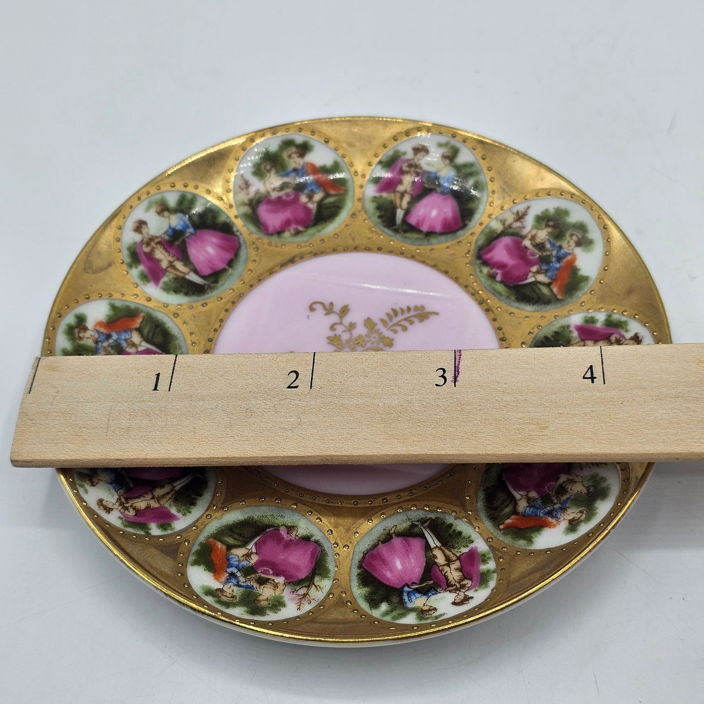 Vintage Royal Vienna Style Porcelain Saucer Featuring a Fragonard-Style Courting Couple Design, Square Cup Indent and Extensive Gold Gilt Trim