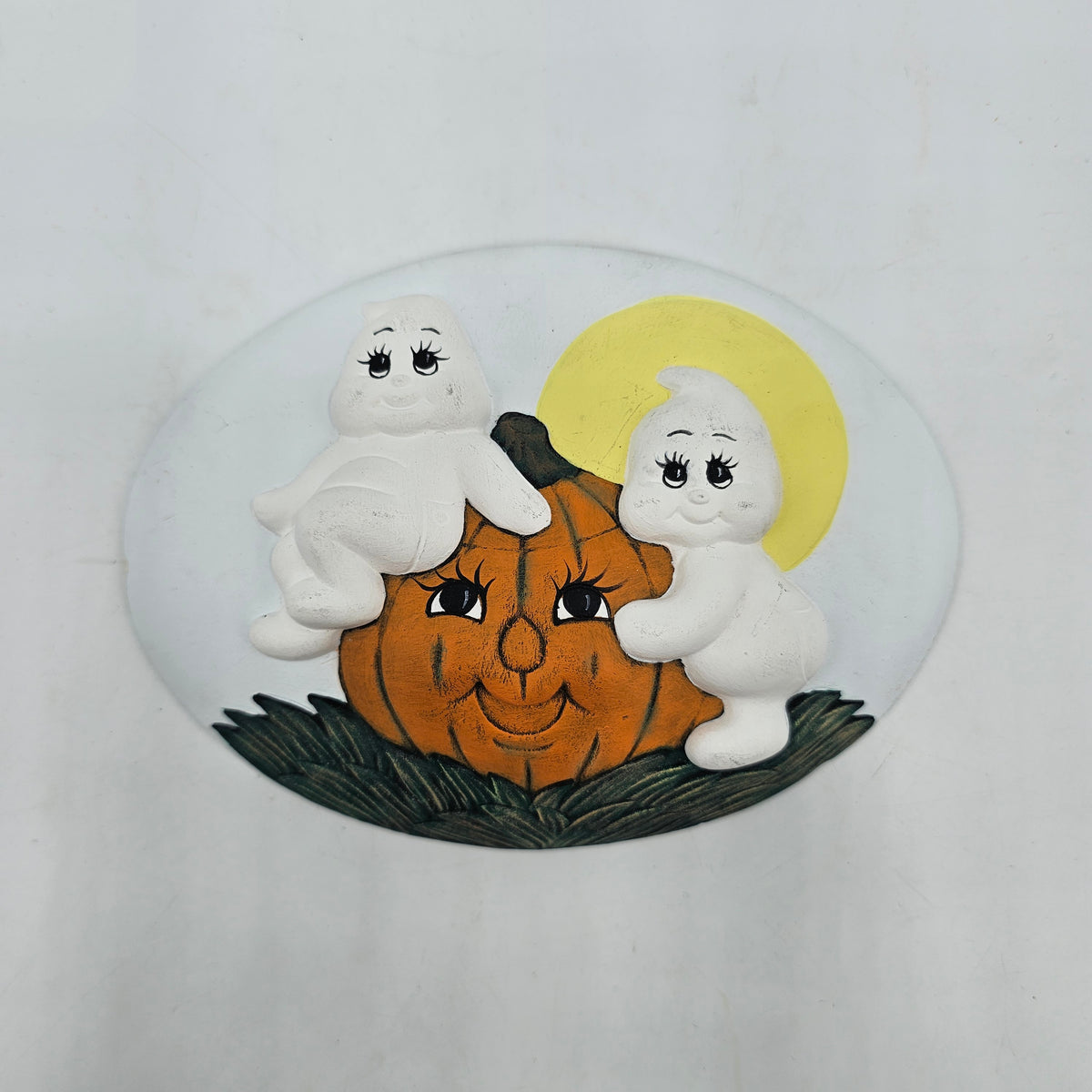 Vintage hand painted ceramic Halloween wall plaque featuring a 3D relief of a pumpkin and two white ghosts