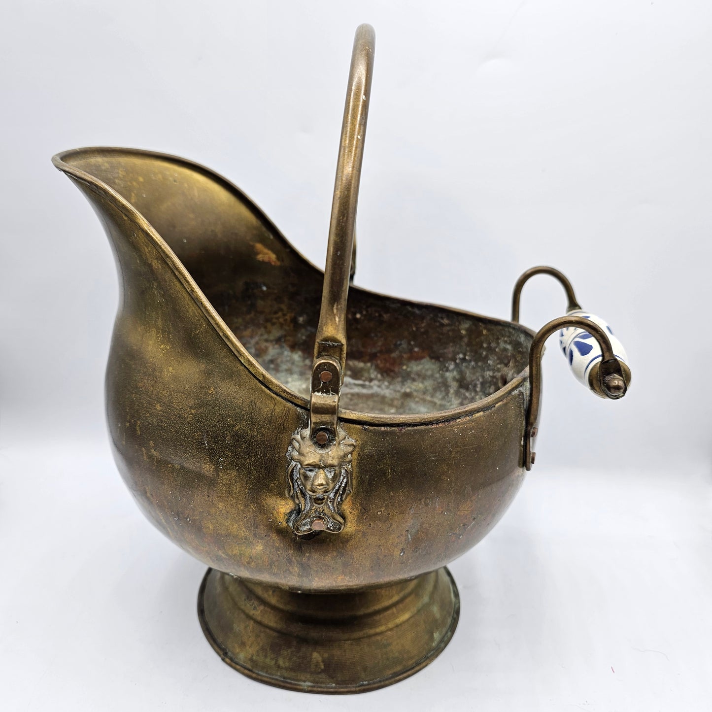 Vintage Brass Fireplace Coal Scuttle with a Blue and White Ceramic Handle and Lion Heads Securing the Handle