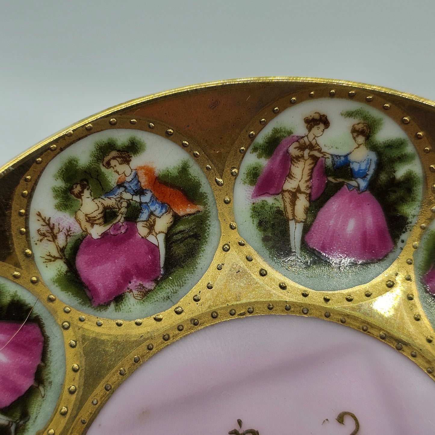 Vintage Royal Vienna Style Porcelain Saucer Featuring a Fragonard-Style Courting Couple Design, Square Cup Indent and Extensive Gold Gilt Trim