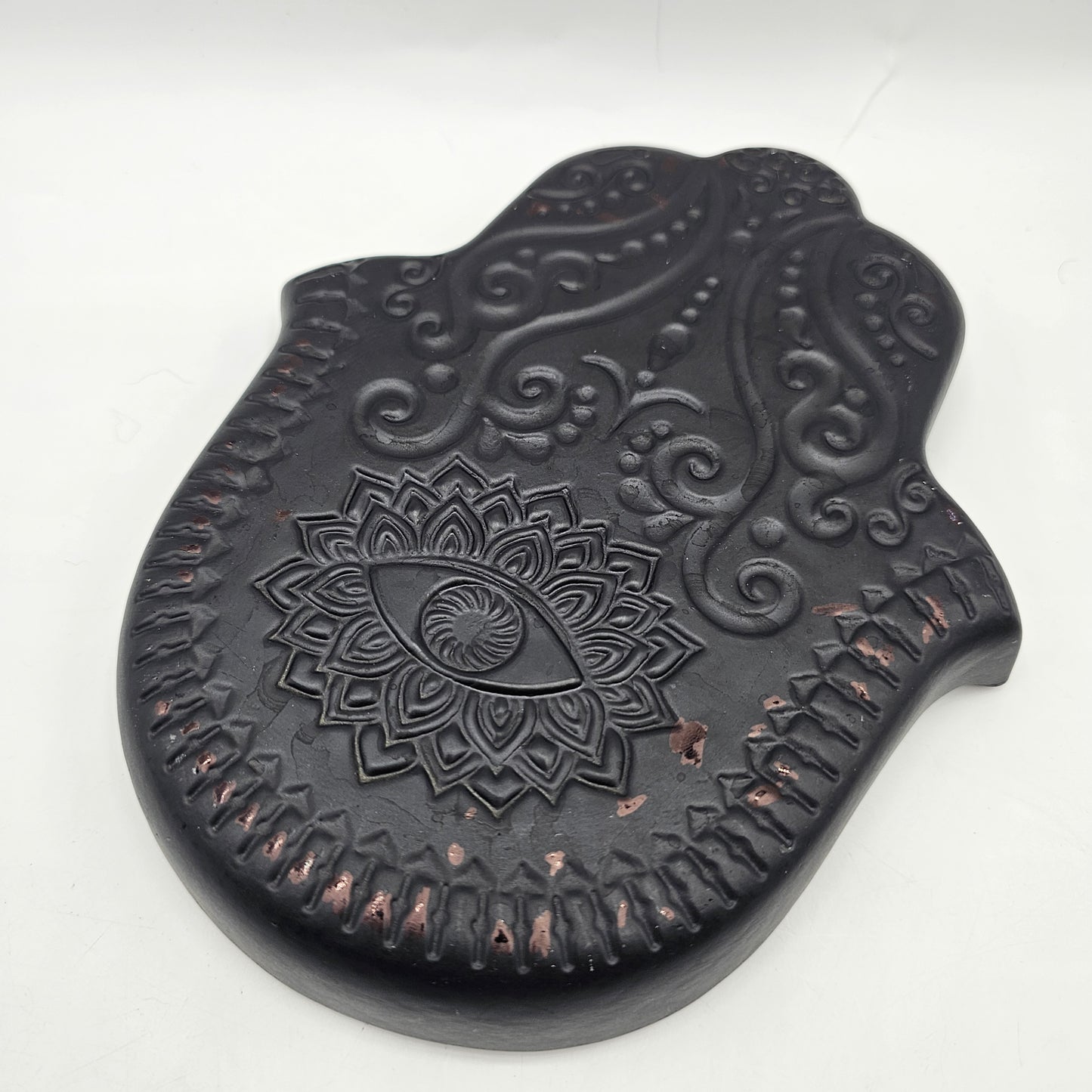 Hamsa hand trinket dish with black glaze, intricate gold-toned evil eye and mandala detailing